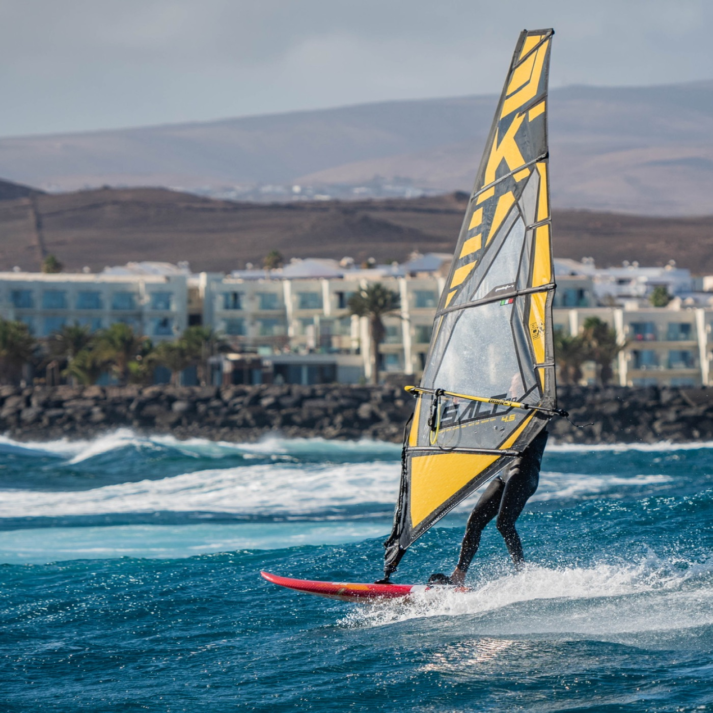 Un windsurfer au canarie en train de surfer sur une vague