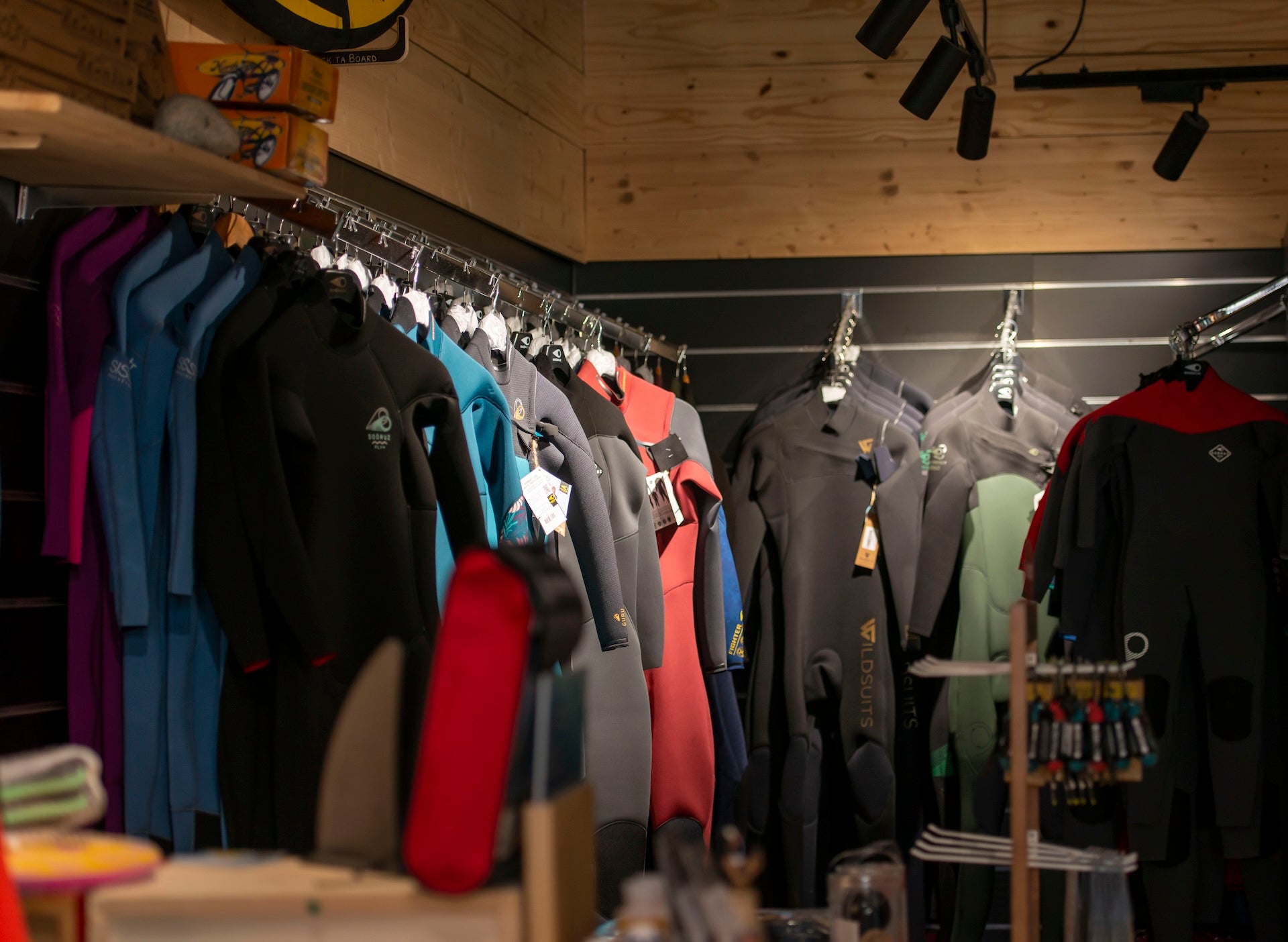 Un rack de combinaisons dans un magasin de surf.