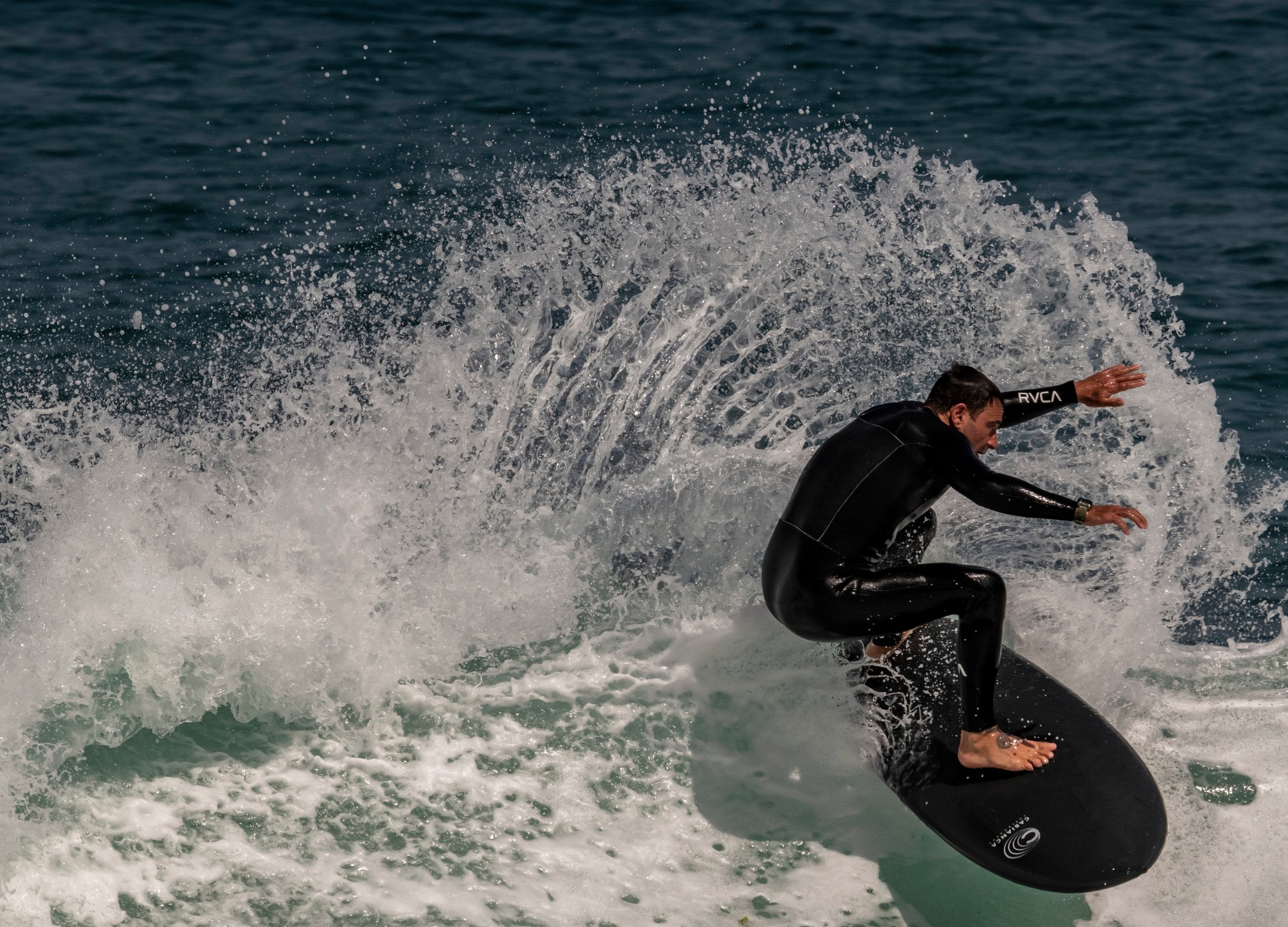 a man riding a wave on top of a surfboard