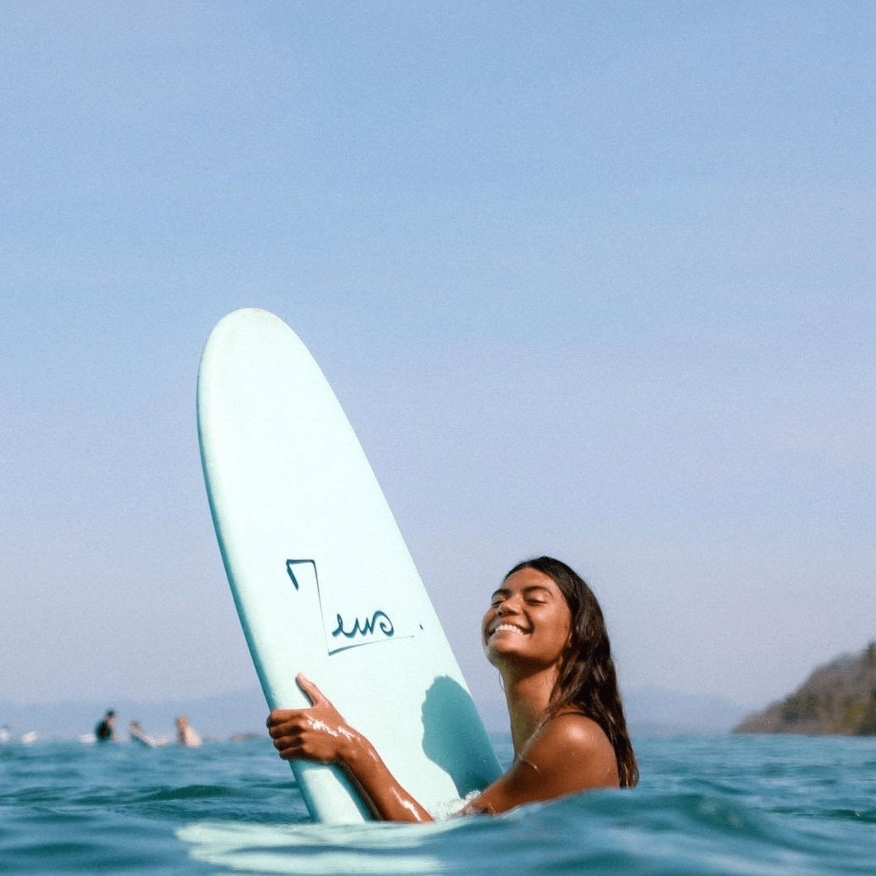 a woman holding a surfboard in the ocean