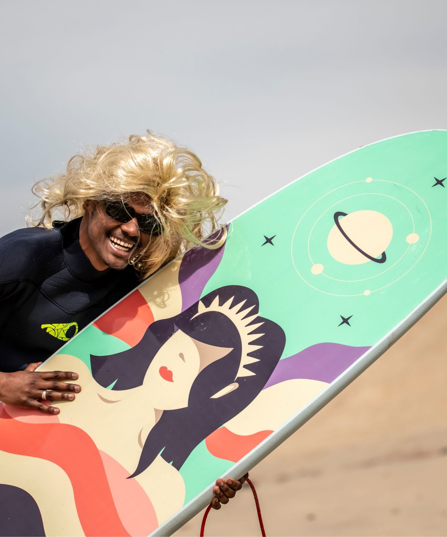 Planche de surf en mousse Zeus avec un surfeur qui porte une péruque 