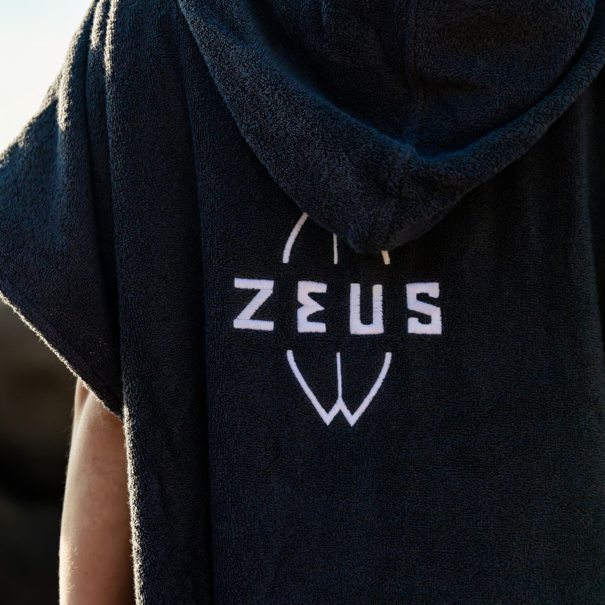 a person wearing a black hoodie with the word jesus printed on it
