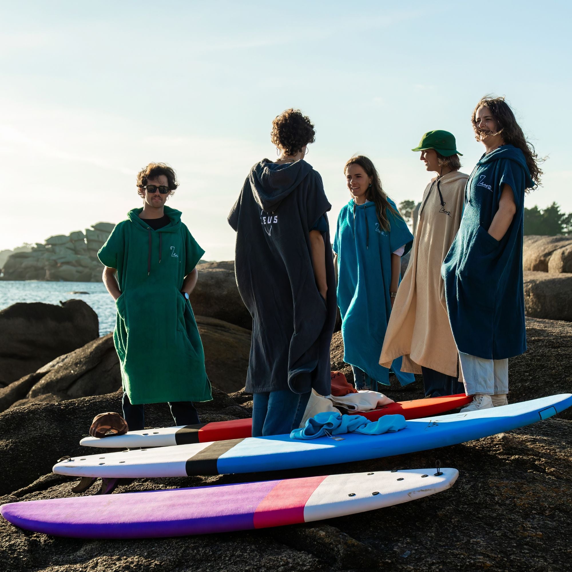 a group of people standing on top of a beach next to surfboards