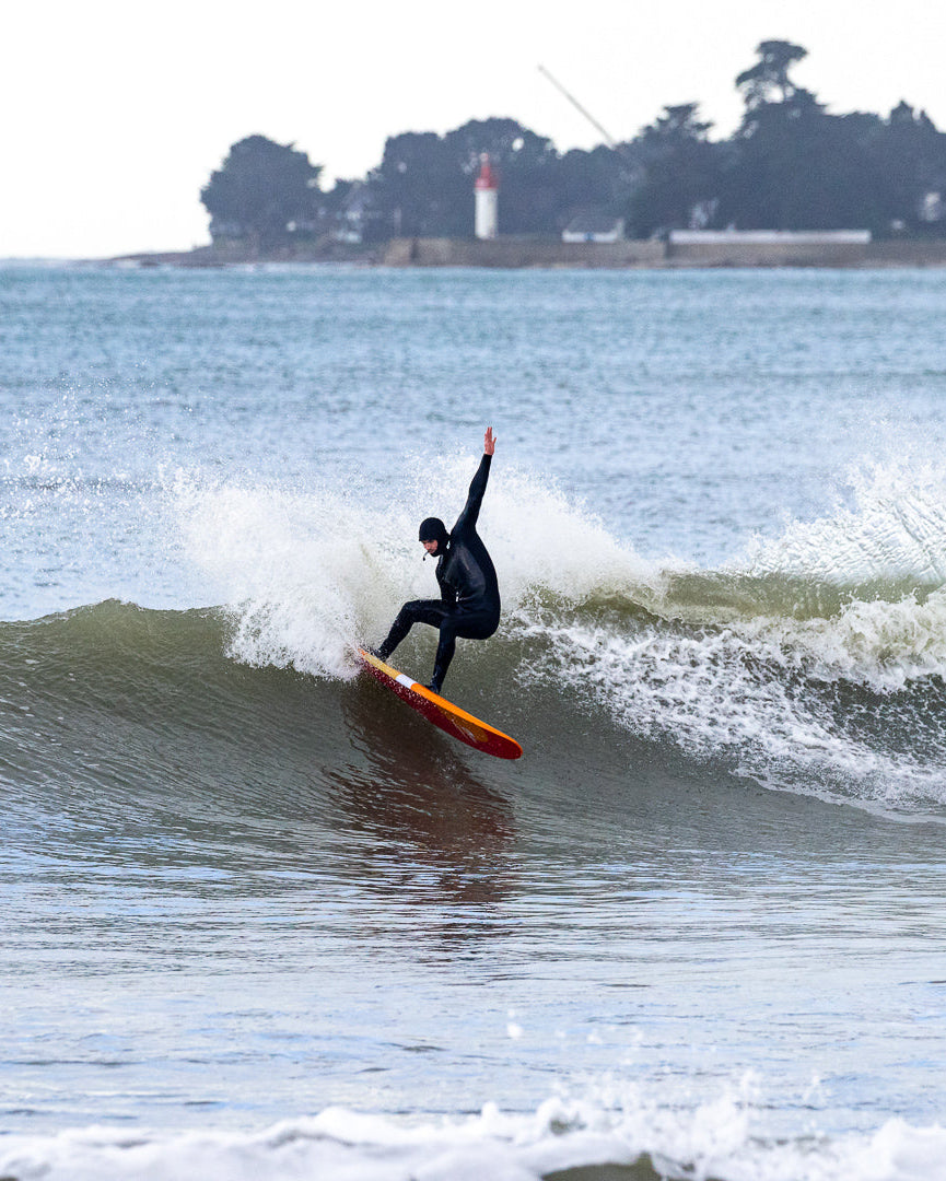 un surfeur en train de faire un virage sur la haut d'ne vague 