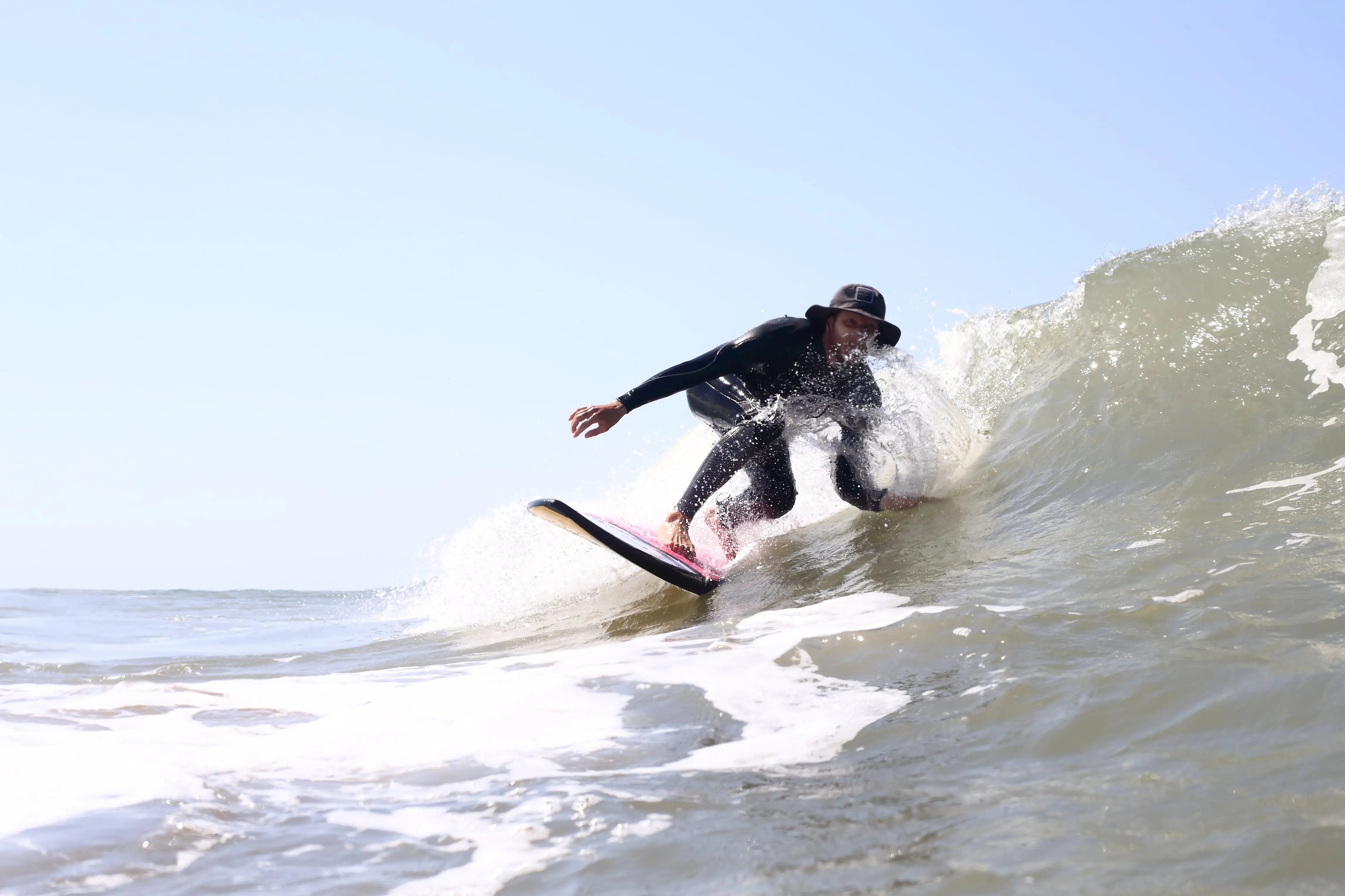 Surfeur en train de prendre une petite vague sur une planche de surf en mosuse