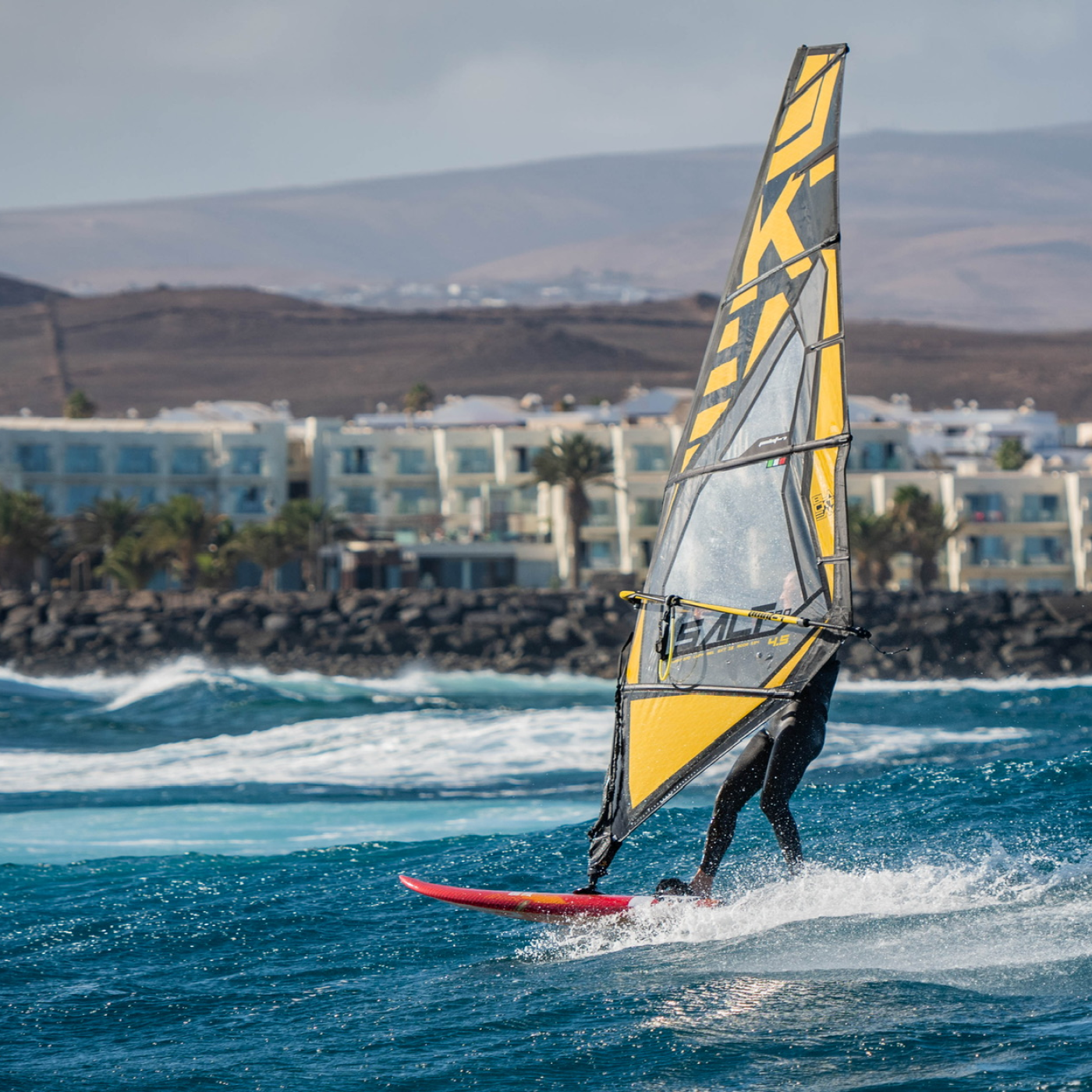 Un windsurfer au canarie en train de surfer sur une vague 