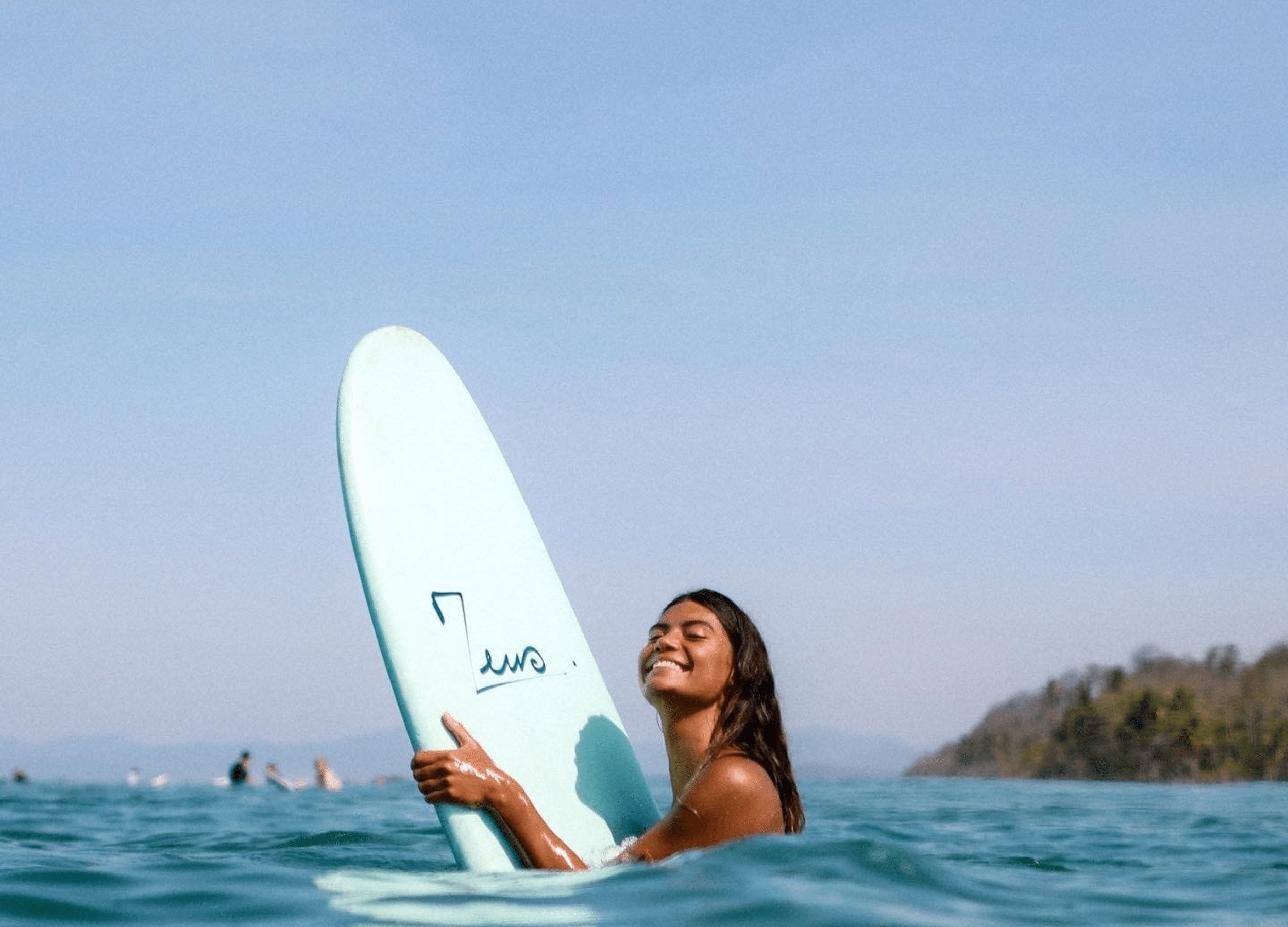 a woman holding a surfboard in the ocean