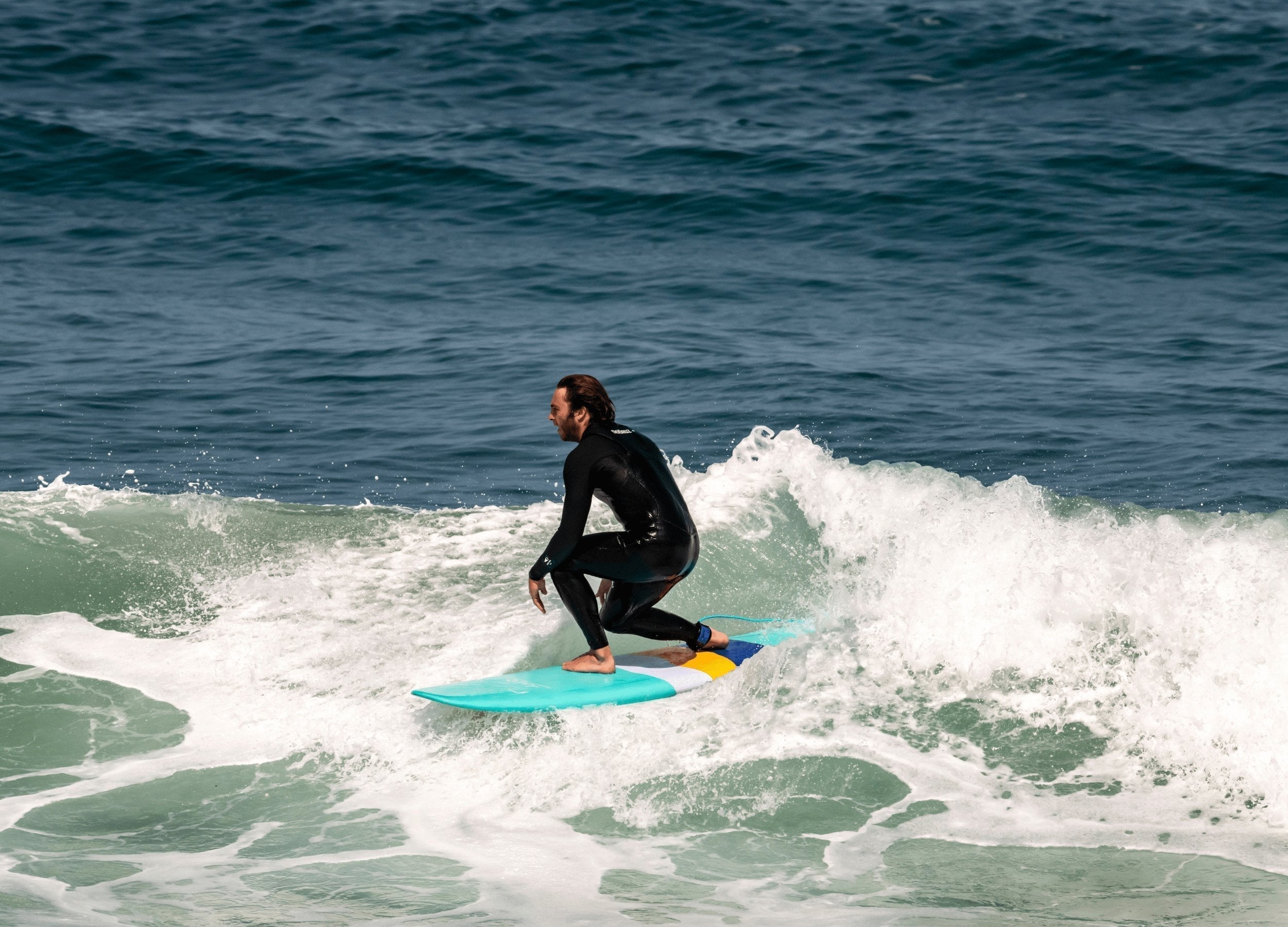 a man riding a surfboard on a wave in the ocean