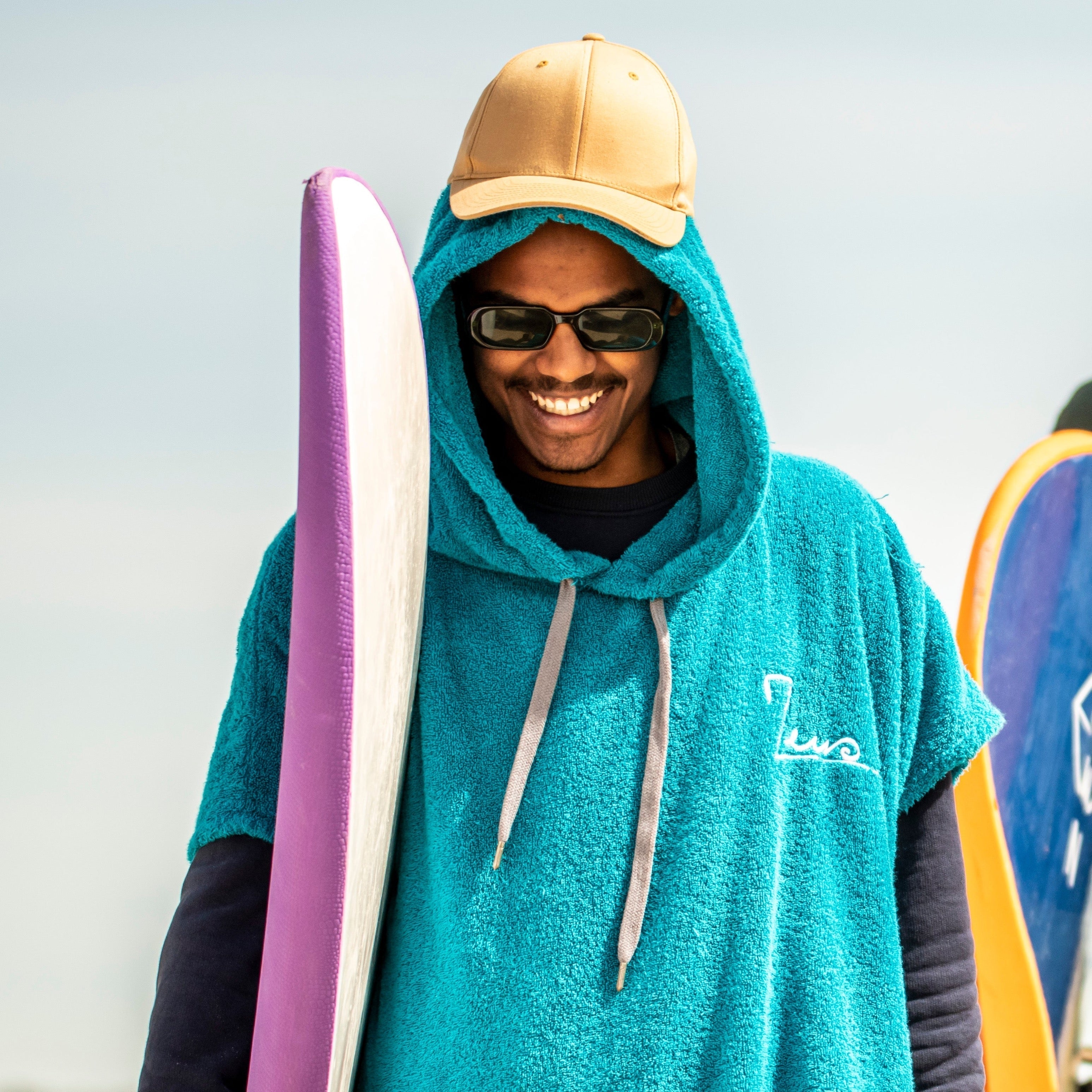 a man in a blue towel holding a surfboard