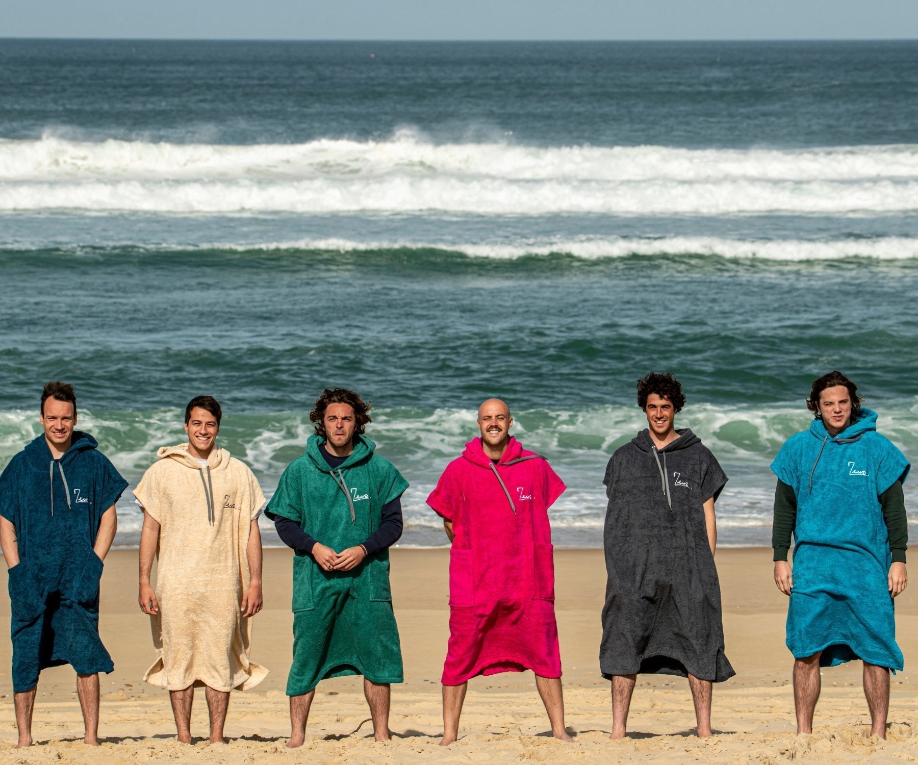 a group of men standing next to each other on a beach