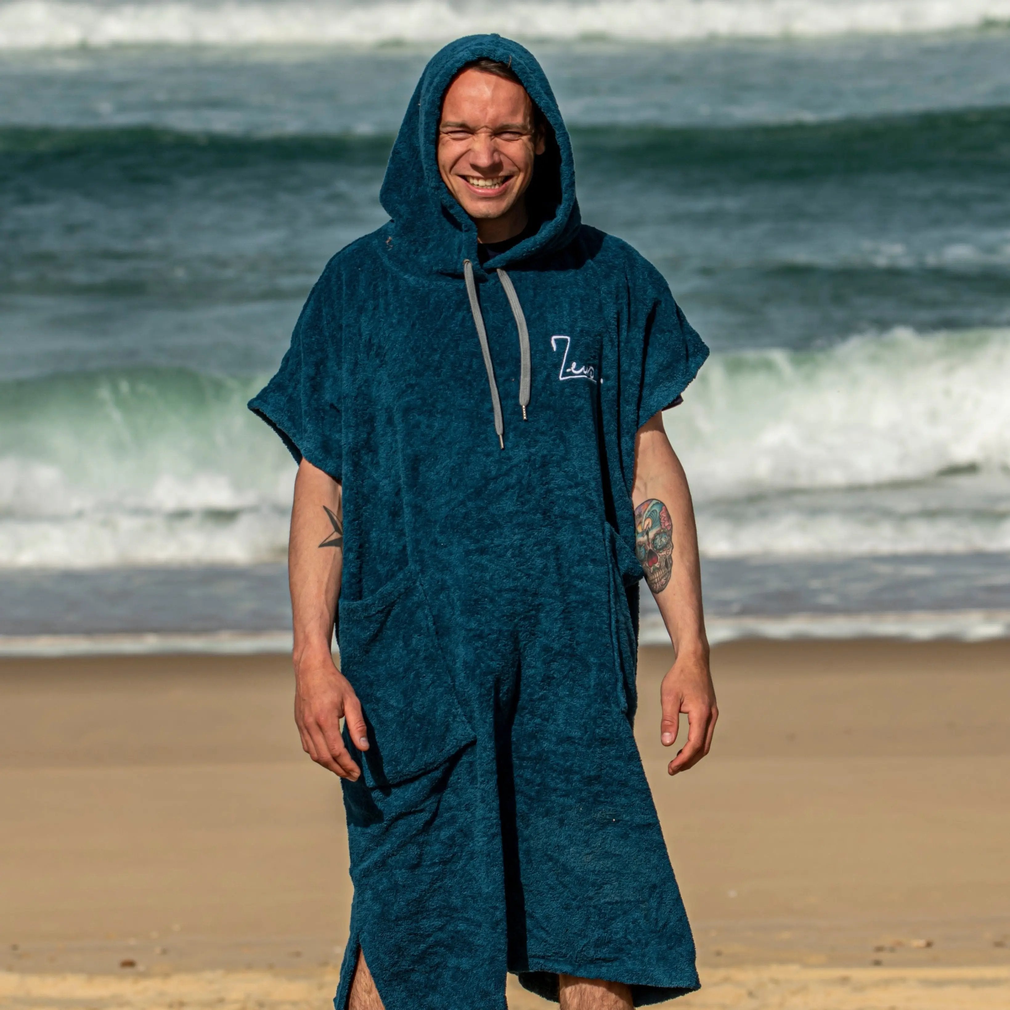 a man standing on the beach in a towel