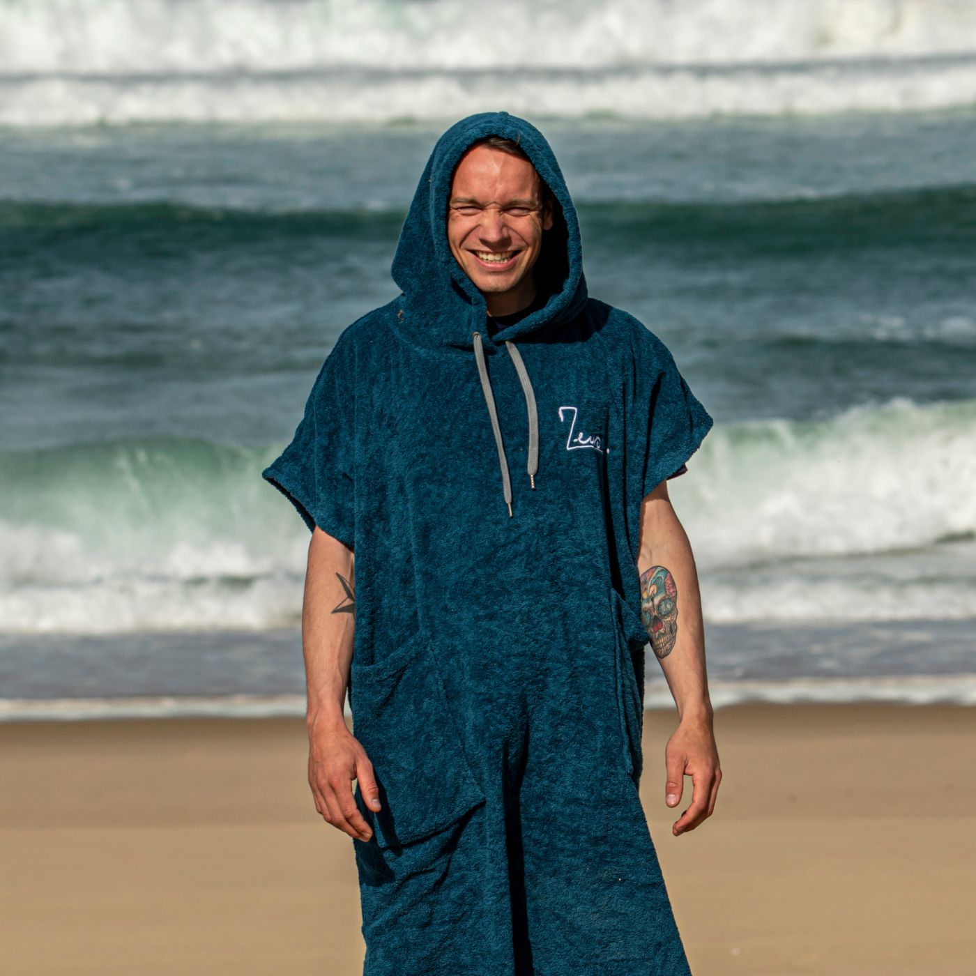 a man standing on a beach with a towel on his head