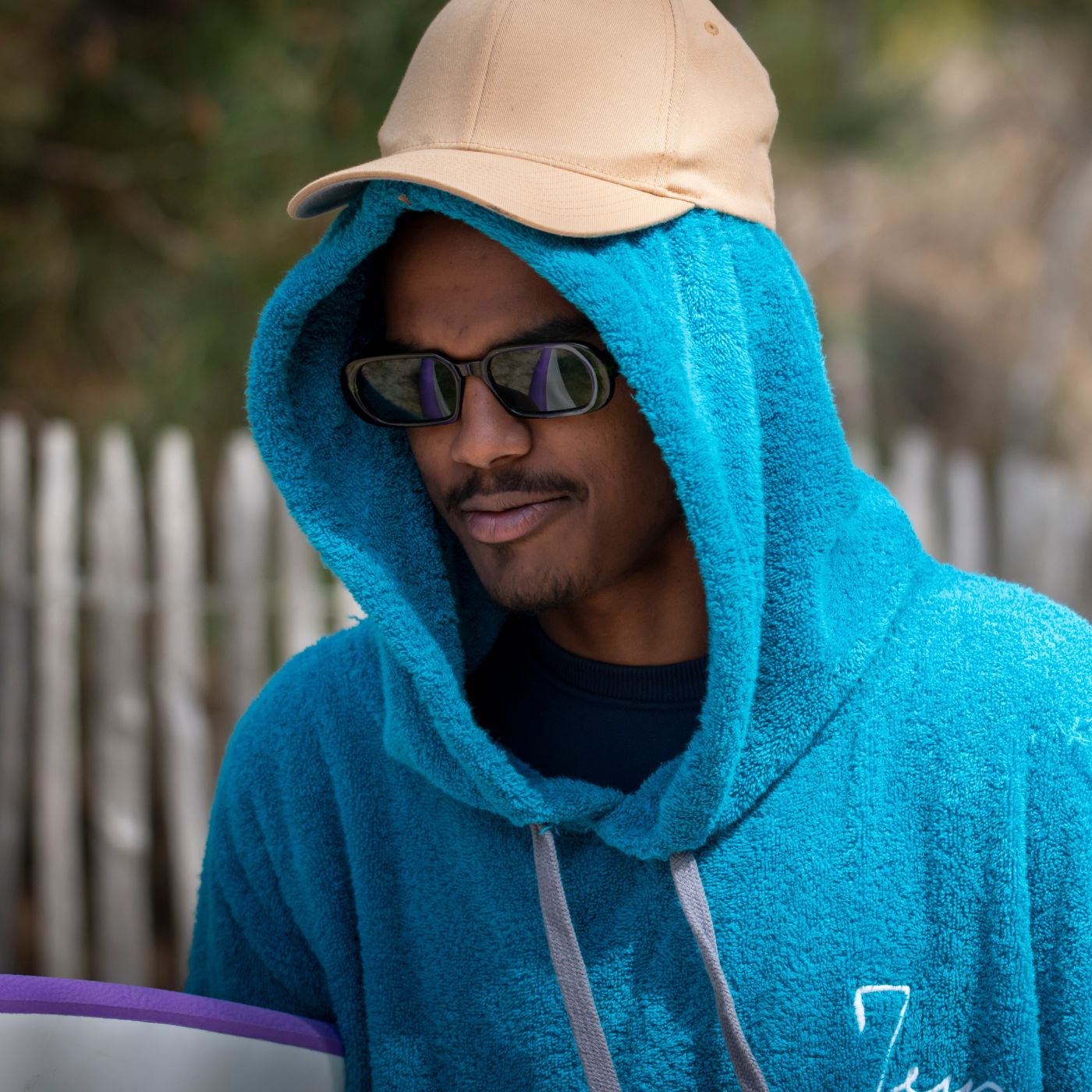 a man wearing a blue towel and a hat