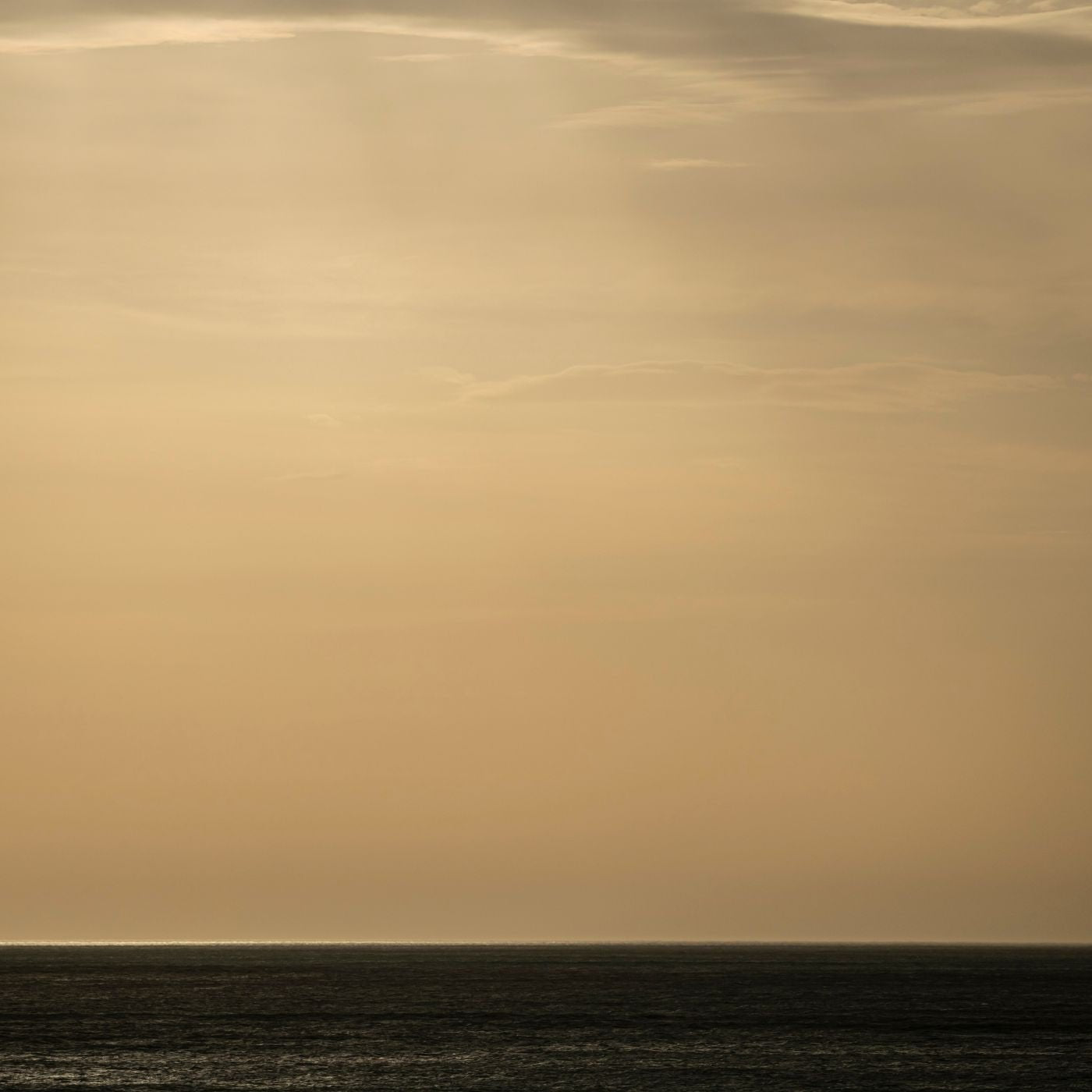 an airplane flying over the ocean on a cloudy day